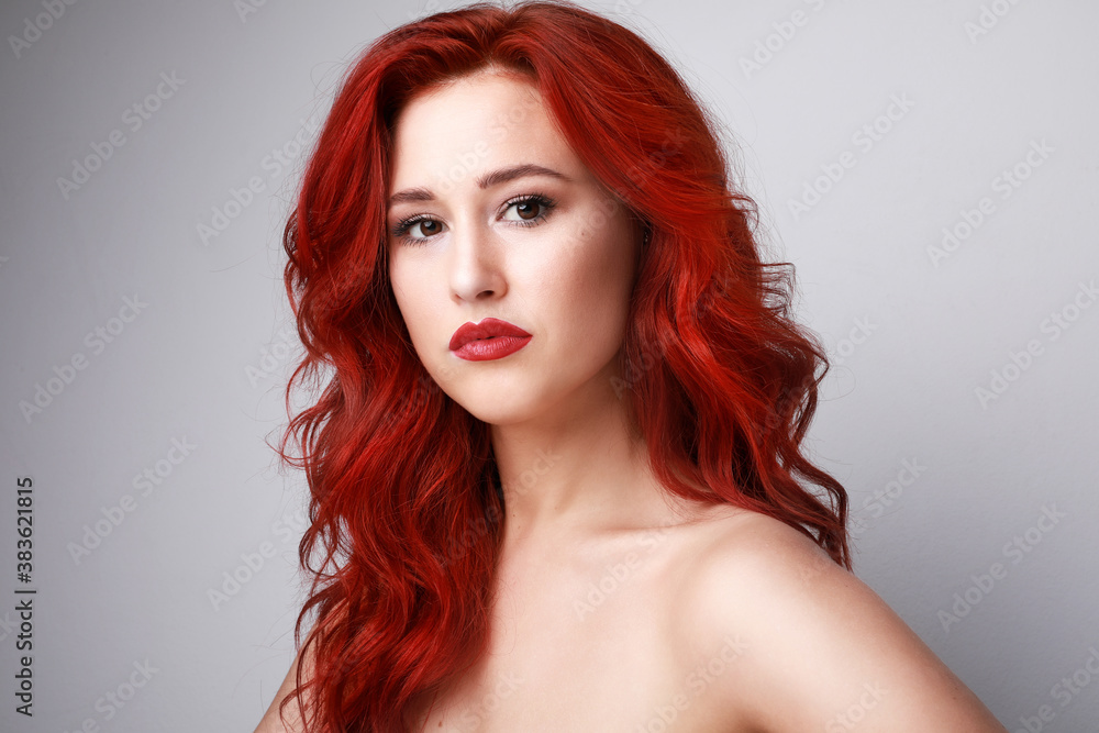 Headshot of sensual woman with beautiful long red hair posing over white background. Space for text.