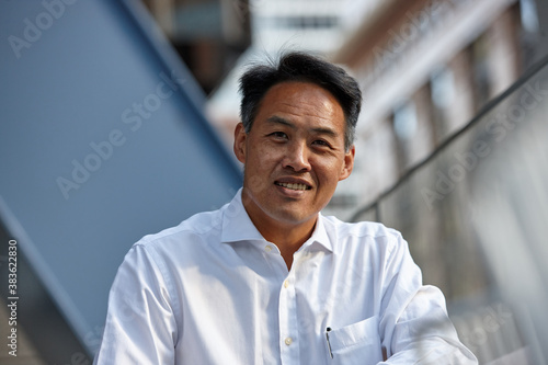 Happy Asian business man wearing open collar shirt photo