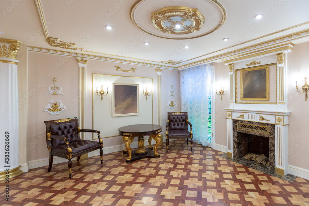 Fototapeta premium luxurious living room interior with beautiful old carved furniture of gold color with decorations on the walls in the style of the royal palace