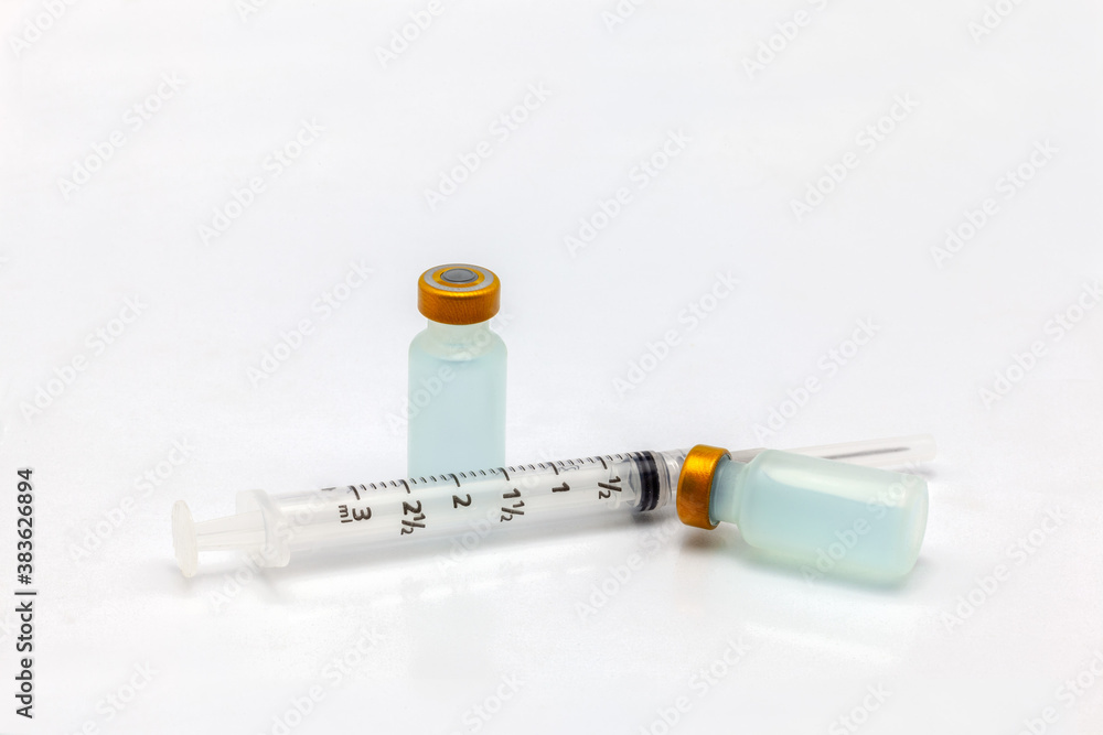 Two isolated glass vaccine bottle with colored liquid and an empty syringe Two isolated glass vaccine bottle with colored liquid and an empty syringe