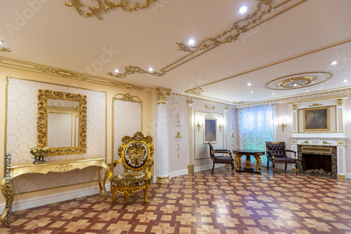 luxurious living room interior with beautiful old carved furniture of gold color with decorations on the walls in the style of the royal palace photo