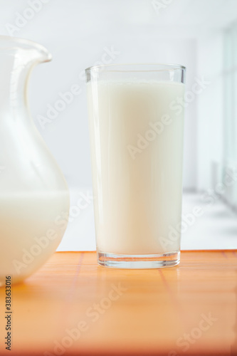 glass of milk and pitcher on table photo