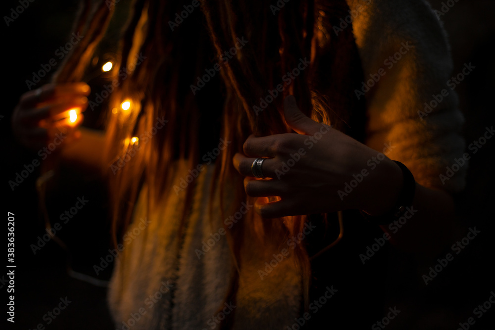 unfocused pagan gothic style photography with woman hand and ring on finger in fire illumination lighting and darkness environment space in night