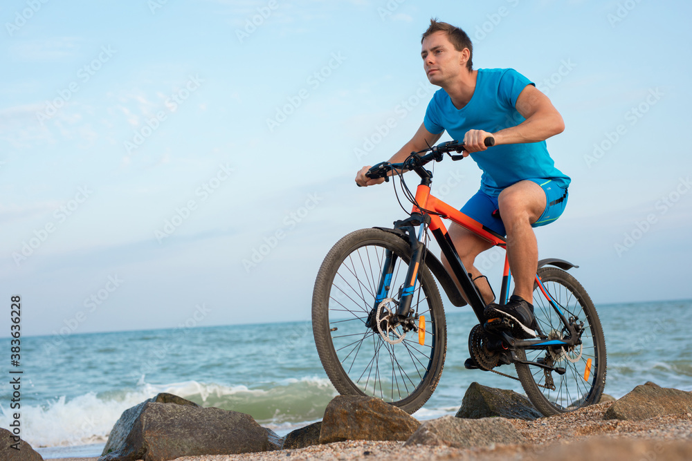 Young man bicycling along a beach