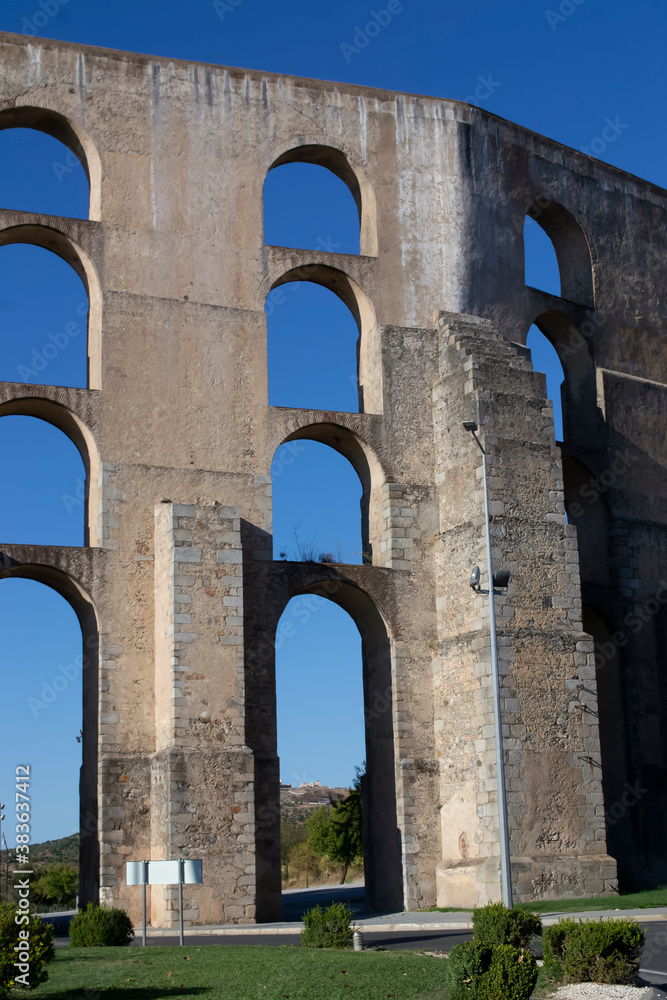 The old aqueduct is a monumental medieval building. Beautiful wallpaper on a background of blue sky.
