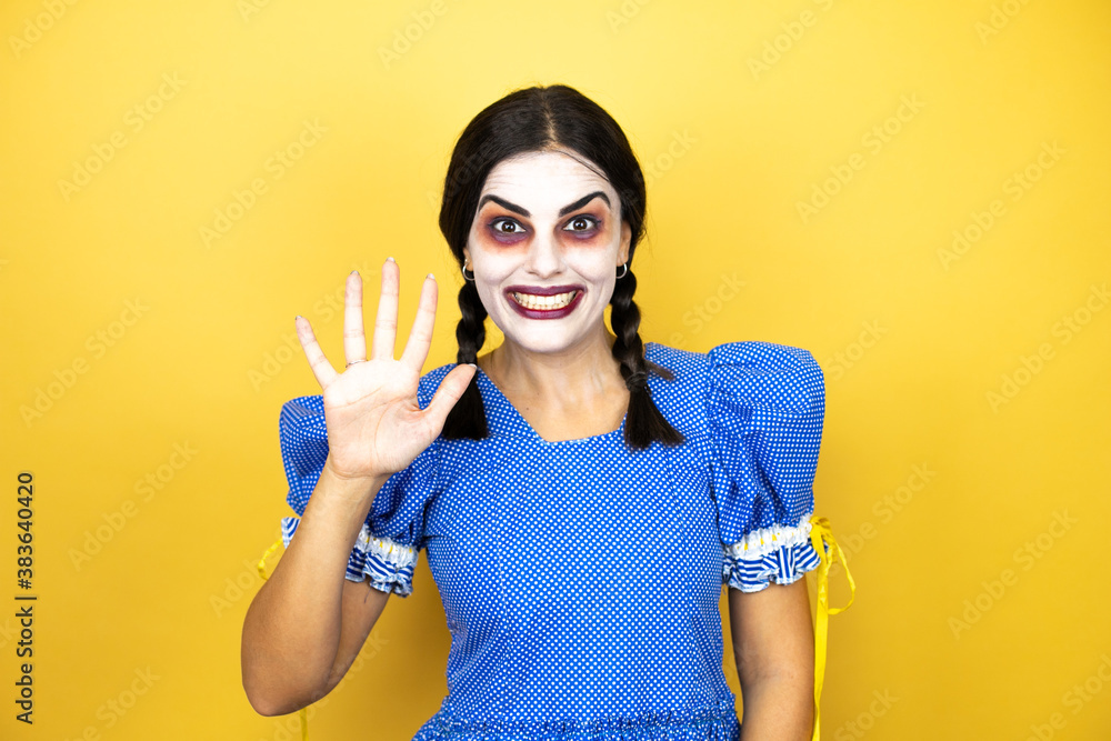 woman wearing a scary doll halloween costume over yellow background showing and pointing up with fingers number five while smiling confident and happy woman wearing a scary doll halloween costume over yellow background showing and pointing up with fingers number five while smiling confident and happy