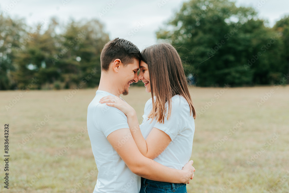 Happy young family smiling and embracing outdoor during fall