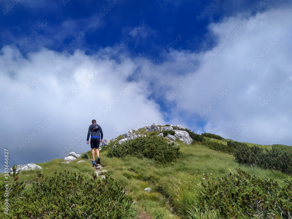 Trail runner and hiker on mount Snjeznik in national park Risnjak, Croatia