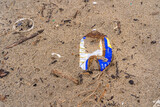 Thrash in sand of beach. Garbage in ocean. Environment contamination