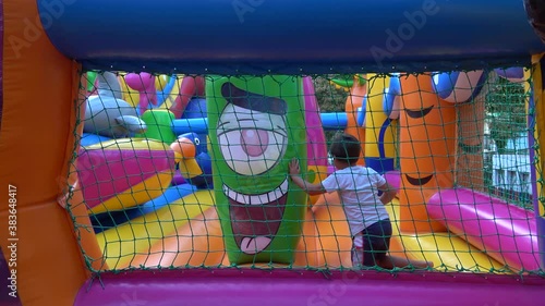 Kherson, Ukraine - 7th of September 2020: 4K Boy jumps and rolls in the bouncy castle
 photo