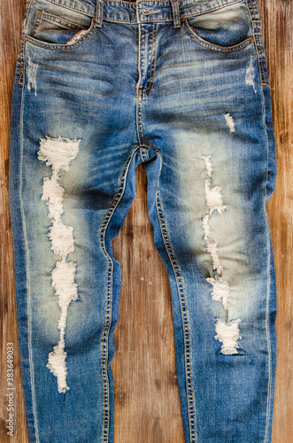 Canvas-taulu Detail of vintage weathered jeans on wood texture