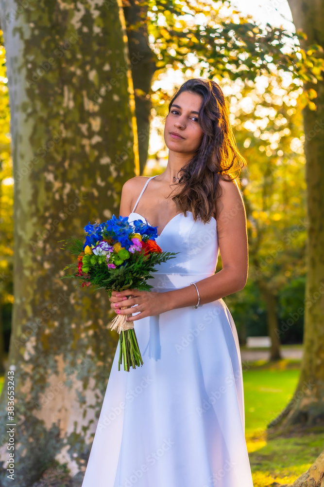 Portrait Caucasian brunette in wedding dress at wedding celebration with bouquet of colorful flowers