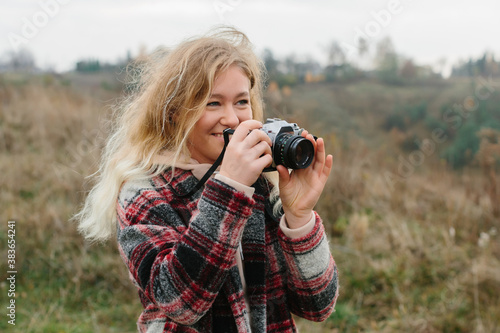 young woman taking photo with old photo camera