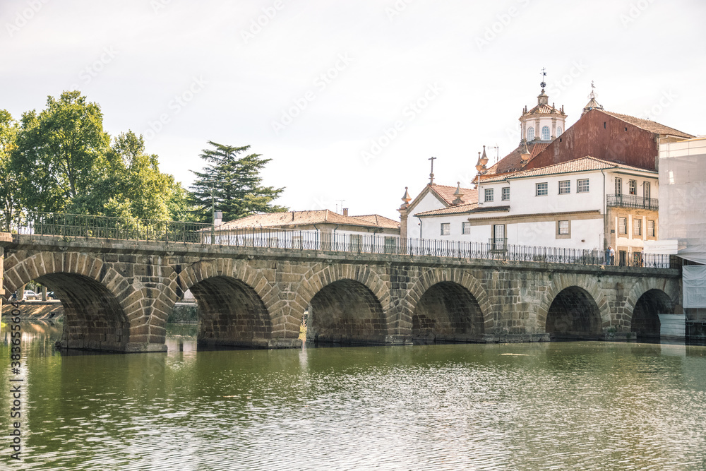 Romanesque bridge over the river. and city on background