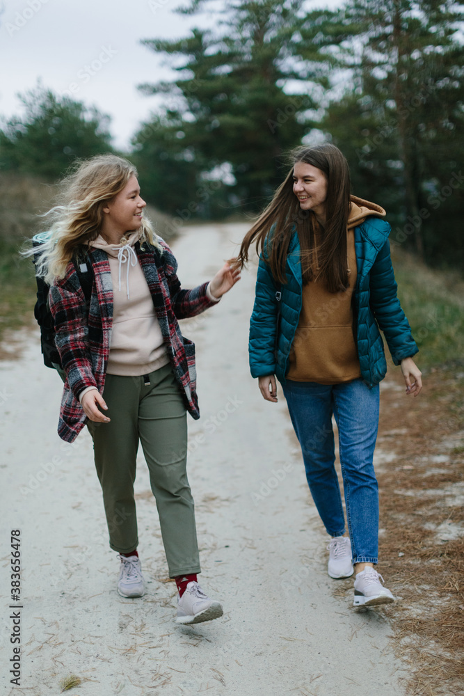 two hikers girls are walking on the road two hikers girls are walking on the road