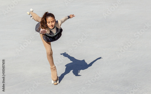 Brown-skinned teenage girl performing a figure skating on wheel photo