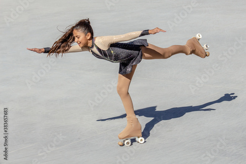 Bild auf Leinwand Teenage girl's back shot performing a figure skating on wheels
