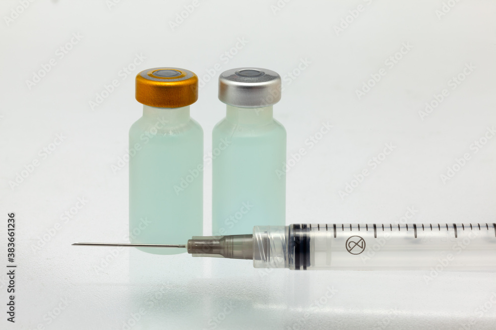 Isolated two plastic vaccine bottle with colored liquid and needle syringe very close high magnification mockup Isolated two plastic vaccine bottle with colored liquid and needle syringe very close high magnification mockup
