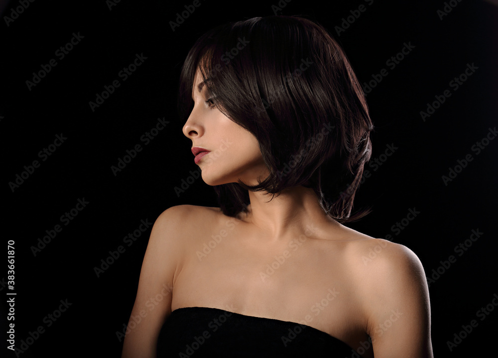 Alluring portrait of short bob hair style woman looking down on black background. Closeup portrait. Alluring portrait of short bob hair style woman looking down on black background. Closeup portrait.