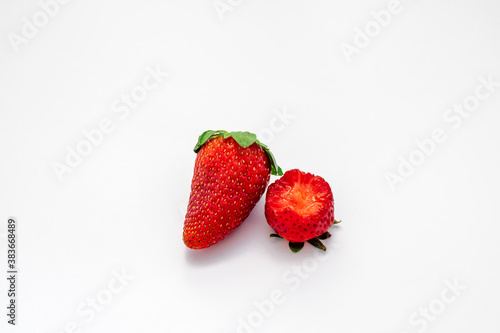 Obraz na płótnie 2 isolated strawberries, one berry has a bite taken from it. w salonie