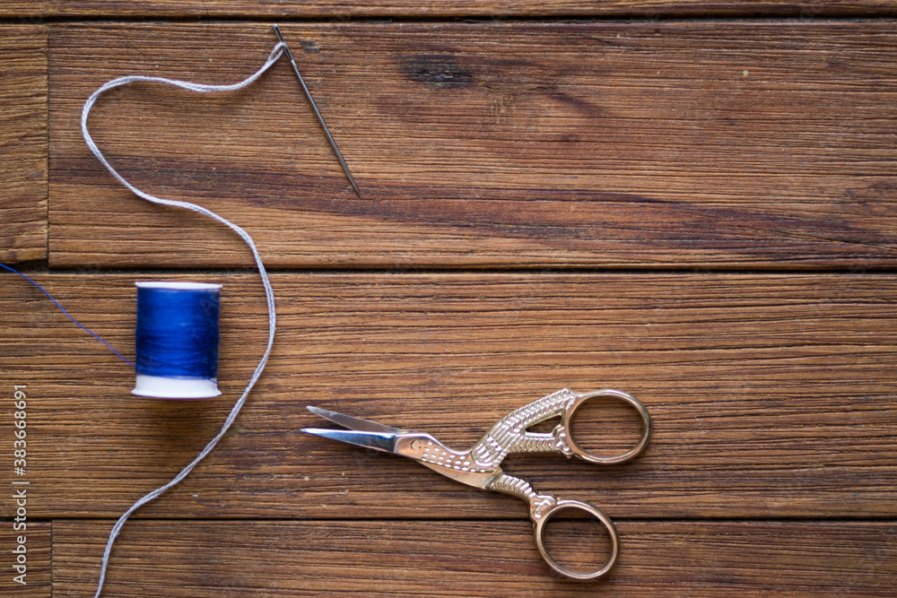 Sewing items on a wooden table. Bird-shaped scissors. Sewing items on a wooden table. Bird-shaped scissors.