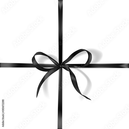 Black bow made of narrow crosswise ribbon with shadow on white background. Criss-cross arrangement