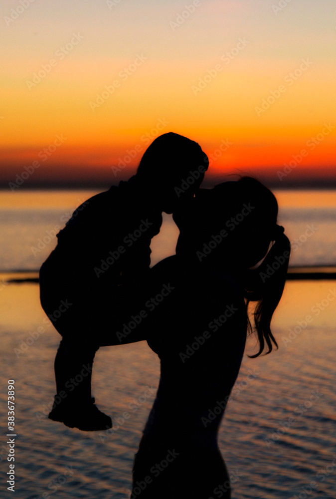 baby and mom on the beach in the sunset