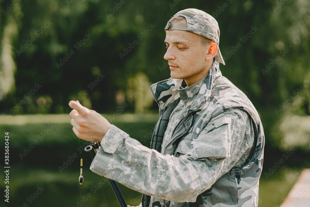 A man fishing on a lake. Guy in a uniform. A man fishing on a lake. Guy in a uniform.
