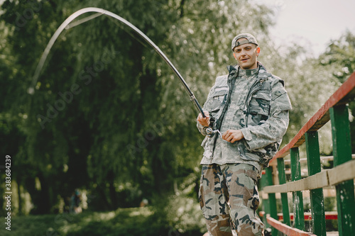 A man fishing on a lake. Guy in a uniform.