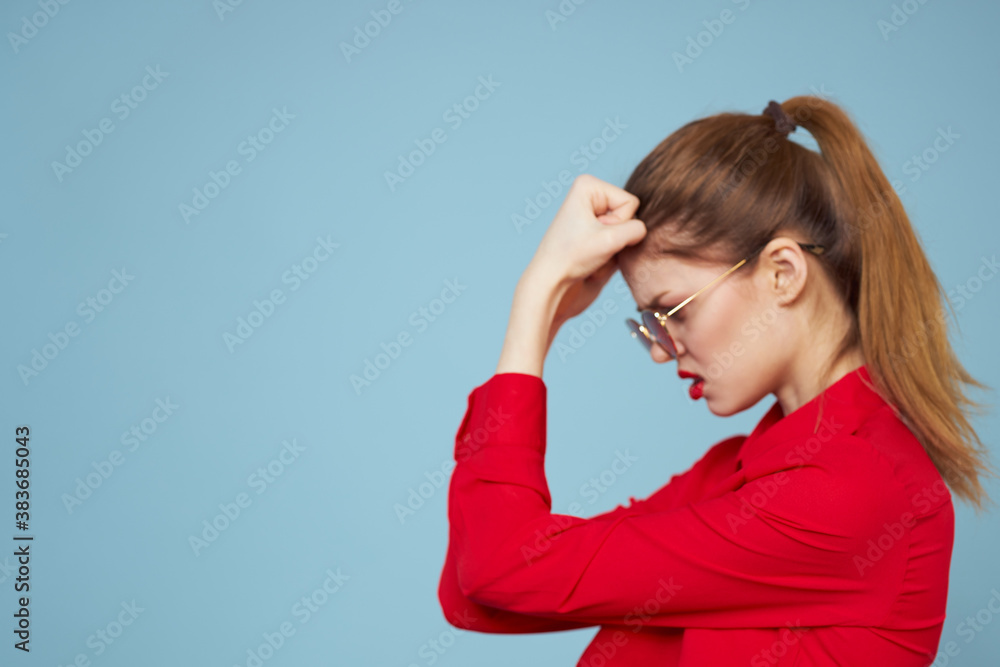 Beautiful woman in dark glasses red shirt bright makeup emotions attractive look blue background Beautiful woman in dark glasses red shirt bright makeup emotions attractive look blue background