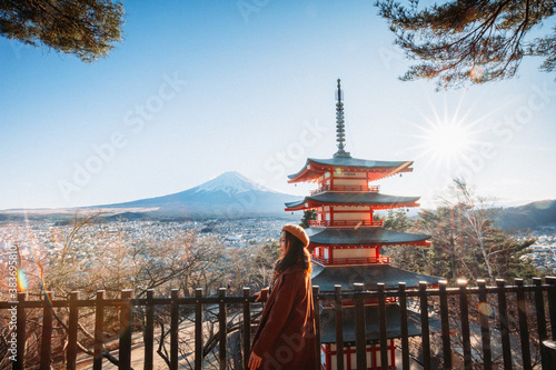 Obraz na płótnie Pretty Girl standing Behind at Beautiful view of mountain Fuji and Chureito pagoda, Fujiyoshida, Japan. Backgound of Fuji Autumn leaves during sunset with clear blue sky. w salonie