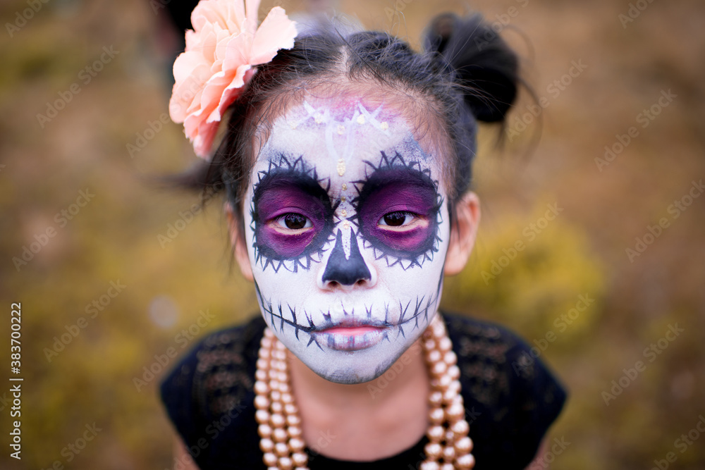 Asian girl sugar skull facepaint with flower on Halloween. Asian girl sugar skull facepaint with flower on Halloween.