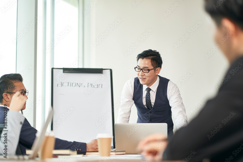 young asian corporate executive facilitating meeting in office young asian corporate executive facilitating meeting in office
