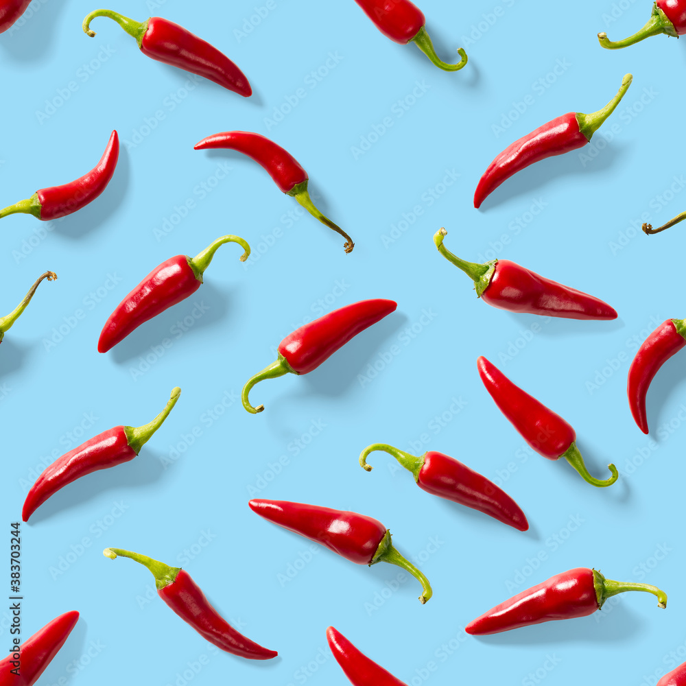 Seamless pattern made of red chili or chilli on blue background. Minimal food pattern. Red hot chilli seamless peppers pattern. Food background. Seamless pattern made of red chili or chilli on blue background. Minimal food pattern. Red hot chilli seamless peppers pattern. Food background.