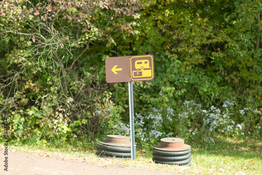 Sign for RV waste dump site. Small brown sign with logo and arrow left