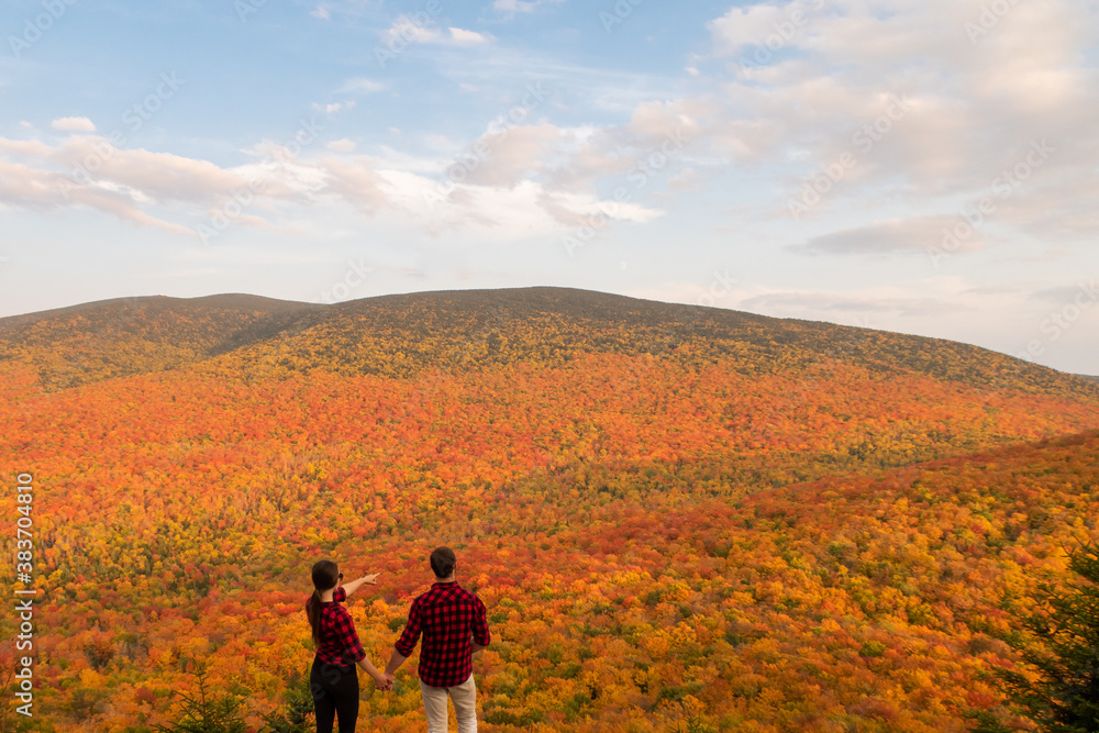 Back view of a young couple admiring the autumnal colours in the Mont-Megantic national park, Canada