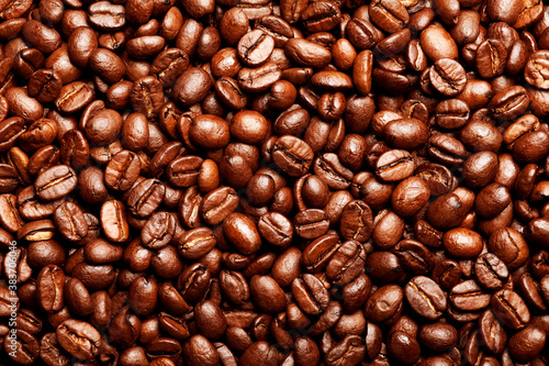 Freshly roasted coffee beans background. Texture of coffee beans. Energy stimulant and smooth java concept with full frame photograph of piled roasting coffee beans backgrounds.