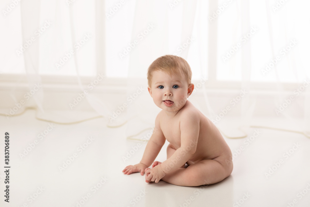 Baby naked sitting on a white background. Studio shot. Baby naked sitting on a white background. Studio shot.