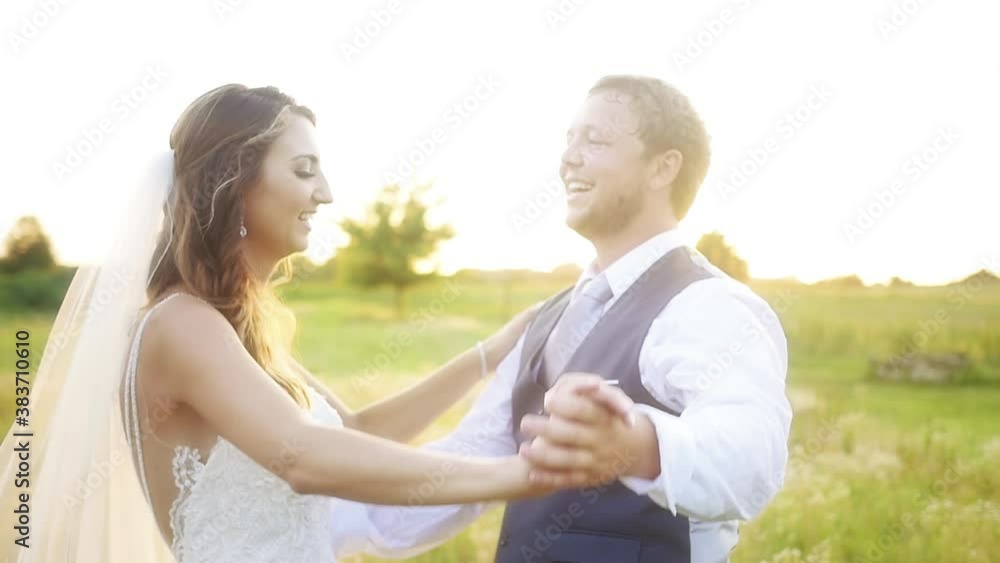 Slow motion shot of a Kansas couple playfully dancing and holding hands and twirling in a meadow at sunset Slow motion shot of a Kansas couple playfully dancing and holding hands and twirling in a meadow at sunset