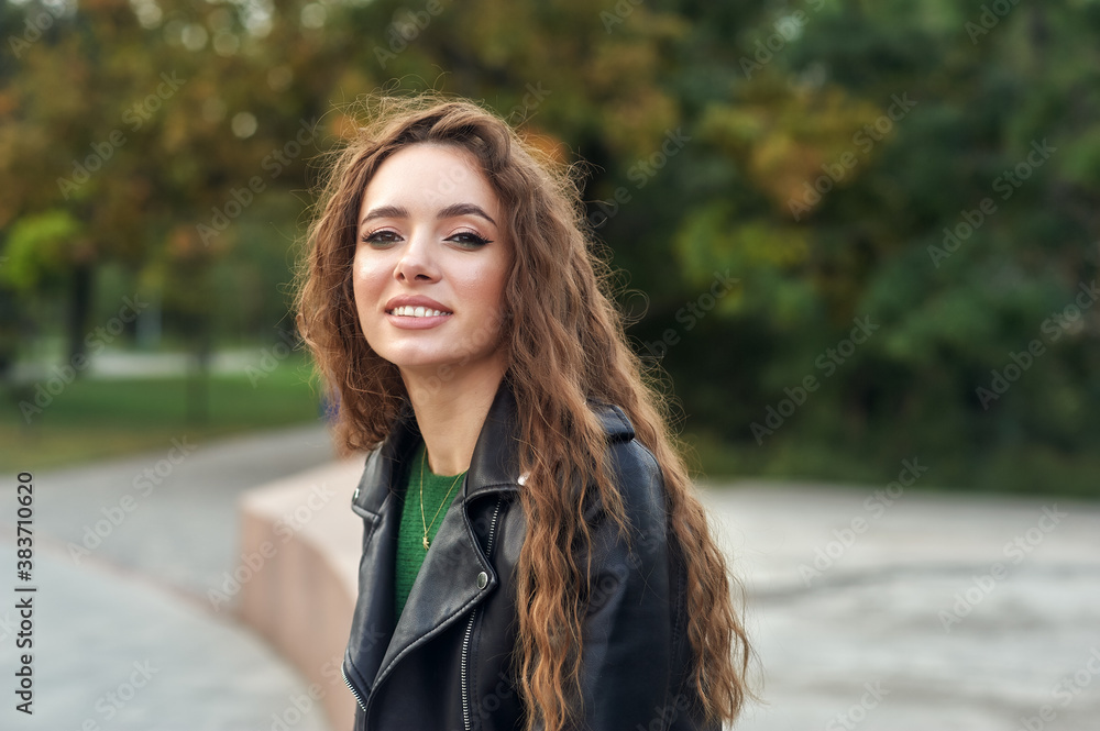 Portrait of a young beautiful girl in a leather jacket in the city