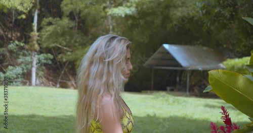 Blonde hair girl admiring a flower at a ranch on the Caribbean island of Trinidad photo