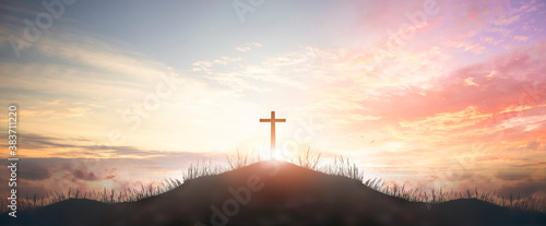 Holy concept: Silhouette cross on mountain sunset background