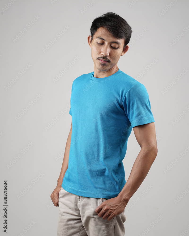 Fototapeta premium Young men in empty blue T-shirts, stylish and posing like famous T-shirt models. Men's t-shirt template and mockup design for print. photo shoot models isolated white background.