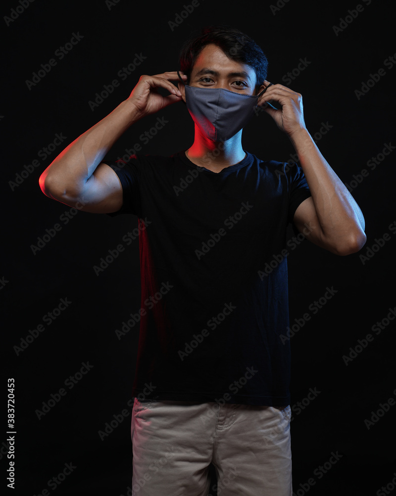 Fototapeta premium Young men in empty black T-shirts and wearing health masks, dress up and pose like famous T-shirt models. Men's t-shirt template and mockup design for print.