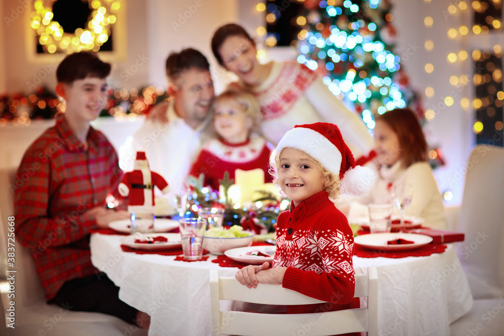 Family with kids having Christmas dinner at tree Family with kids having Christmas dinner at tree