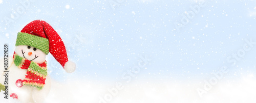 Snowman toy on the bokeh winter background . Christmas background. Copy space for text. Banner
