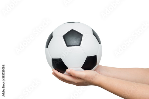 Young man holding classic leather soccer ball isolated on white background. Traditional black and white football equipment to play a competitive game. This photo can be used for sport concept.