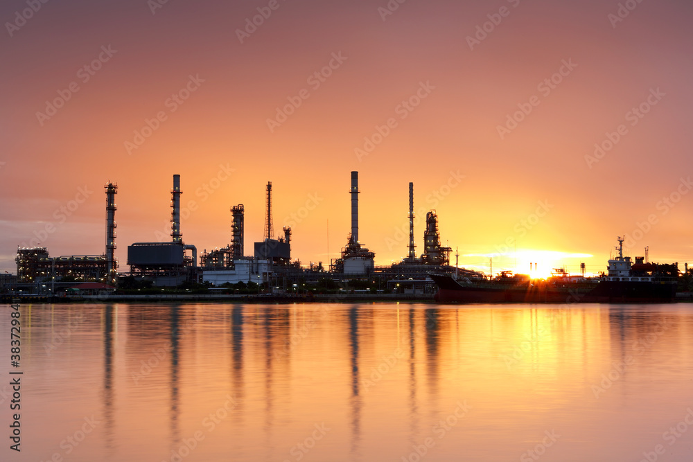 Oil refinery with water reflection at sunrise
