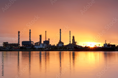 Oil refinery with water reflection at sunrise