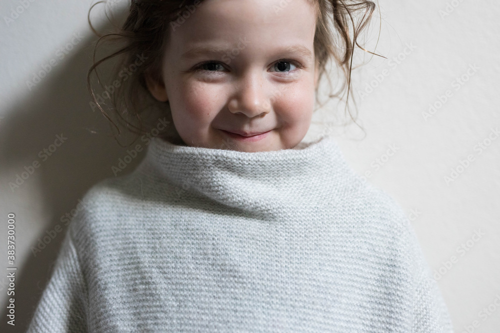 Hands of a small child clasped together with light grey woven jumper Hands of a small child clasped together with light grey woven jumper